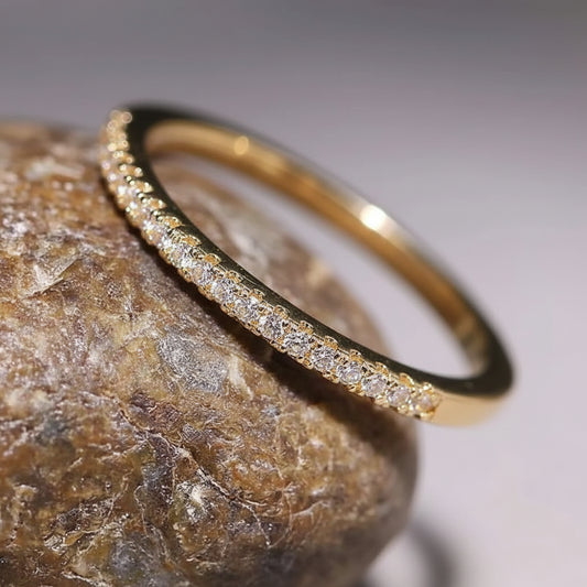 Gold ring with small diamonds on a stone surface