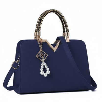 Navy blue handbag with decorative handle and charm on a white background